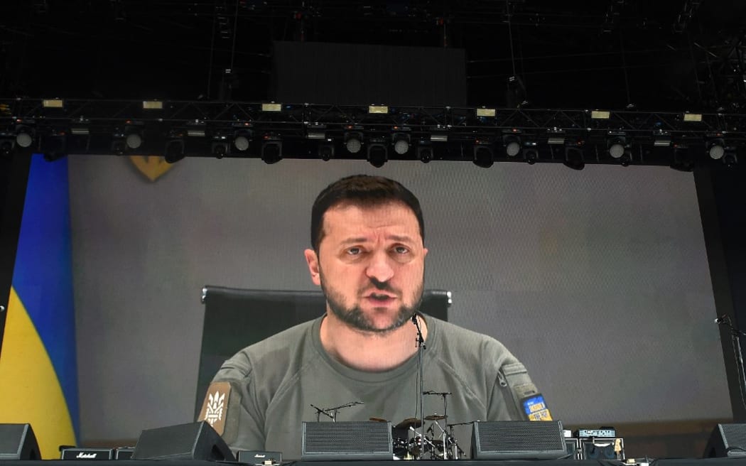 Ukraine's President Volodymyr Zelensky addresses festivalgoers via a video link during the Glastonbury festival near the village of Pilton in Somerset, southwest England, on June 24, 2022. - More than 200,000 music fans and megastars Paul McCartney, Billie Eilish and Kendrick Lamar descend on the English countryside this week as Glastonbury Festival returns after a three-year hiatus. The coronavirus pandemic forced organisers to cancel the last two years' events, and those going this year face an arduous journey battling three days of major rail strikes across the country. (Photo by ANDY BUCHANAN / AFP)