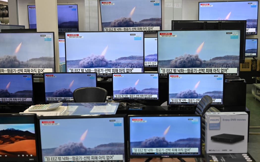 Television screens show file footage of North Korea's missile test as a news programme broadcasts reports about North Korea's suspected ballistic missile test, at an electronics mall in Seoul on March 25, 2021.