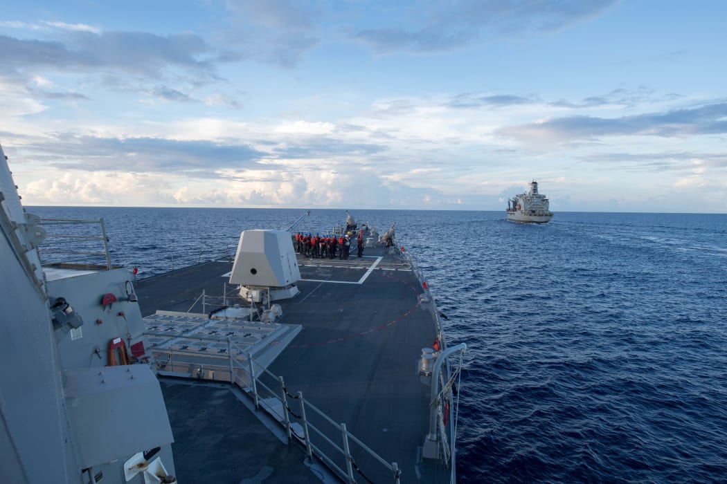 Arleigh Burke-class guided-missile destroyer USS Dewey prepares for a replenishment-at-sea with USNS Pecos, right, in the South China Sea on 19 May 2017.