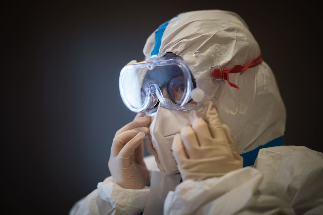 A member of the medical team of the Second Military Medical University puts on protective clothing at Hankou Hospital in Wuhan on 27 January, 2020.