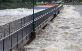 This recent undated handout picture provided by the Queensland Fire and Emergency Services and received by AFP on February 3, 2019 shows floodwaters as they rush over the Aplins Weir in Townsville after days of torrential rain.