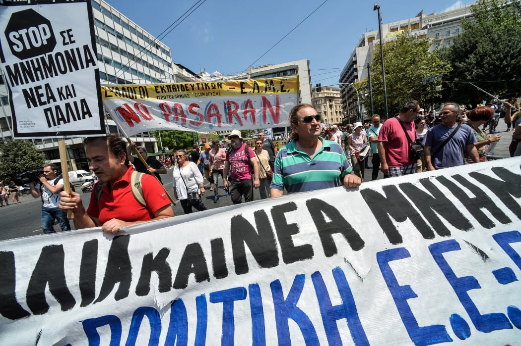 Protestors hold a banner during a peaceful march in central Athens, marking a 24-hour public sector workers' strike.