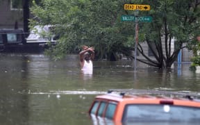 A man waves down a rescue crew as he tries to leave an area of Houston that has been swamped by floodwaters.
