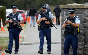 Armed police officers stand guard during the burial ceremony of the victims killed in Christchurch's mosque attacks at the Memorial Park Cemetery in Christchurch, New Zealand on March 21, 2019.
