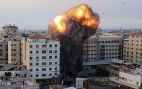Fire and smoke rise after an Israeli air strike targeted the National Bank on Gaza City, on October 8, 2023.
