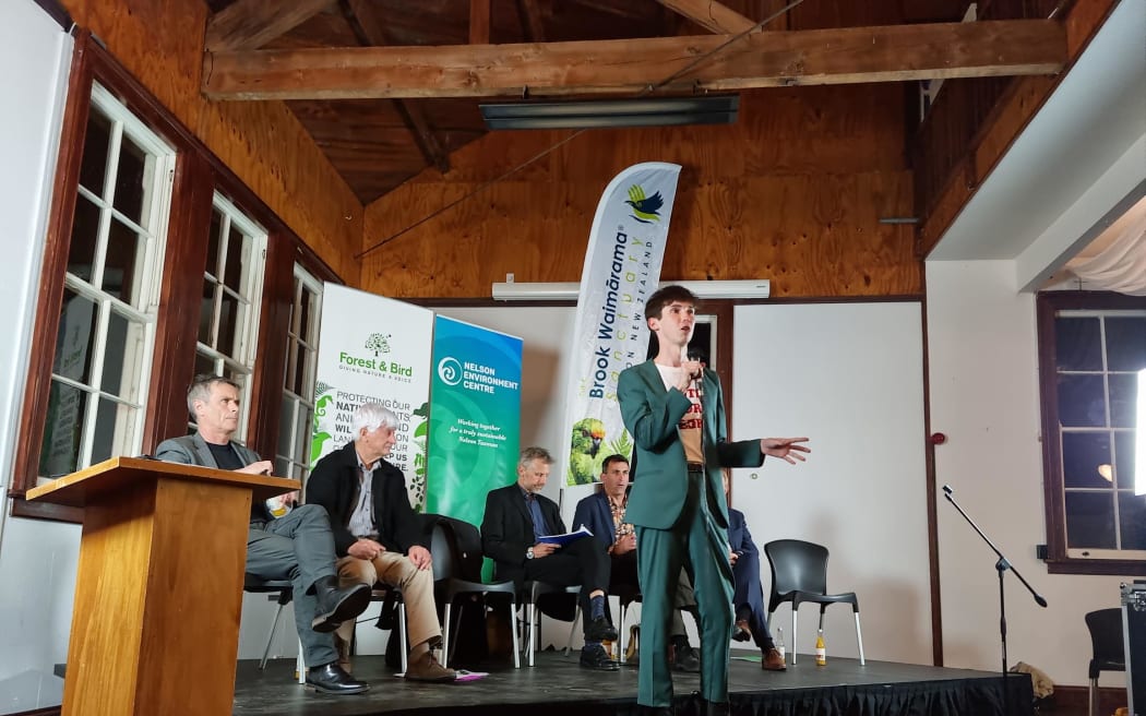 Nelson mayoral candidate Rohan O'Neal-Stevens speaks before a public meeting, with (seated from left) Matt Lawrey, Kerry Neal, Richard Osmaston, Tim Skinner and Nick Smith.