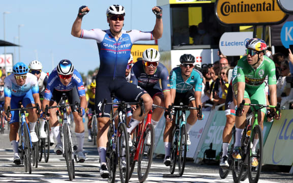 The Dutch rider of the Quick-Step Alpha Vinyl Team, Fabio Jakobsen (L), celebrates flanked from the second place the Belgian rider of the Jumbo-Visma team, Wout Van Aert, when he crosses the finish line to win the 2nd stage of the 109th edition of the Tour de France cycling race, 202.2 km between Roskilde and Nyborg, Denmark, on July 2, 2022. (Photo by Thomas SAMSON / AFP)