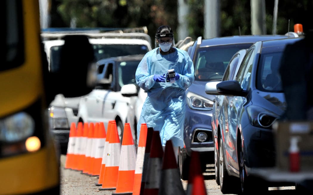 A medical worker performs a PCR test at a drive-through Covid-19 test centre in western Sydney on December 21, 2021.
