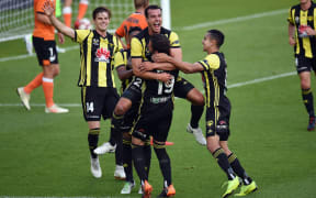 Wellington Phoenix defender Steven Taylor and team-mates celebrate their opening goal against the Brisbane Roar.