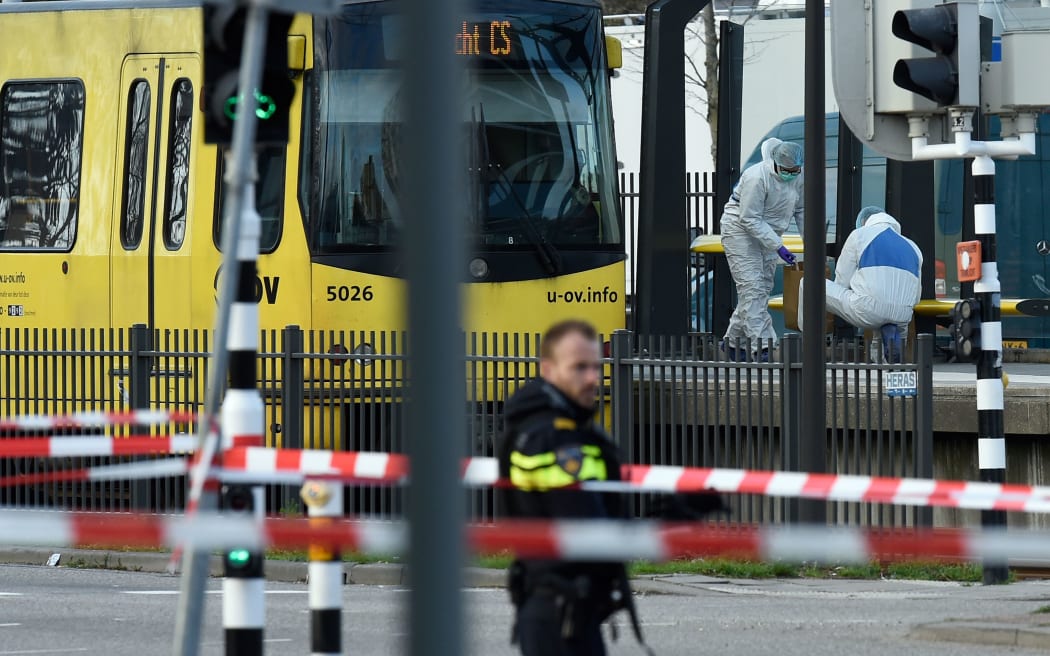 Police officer and forensic investigators near  near a tram in Utrecht where a gunman opened fire killing three people.