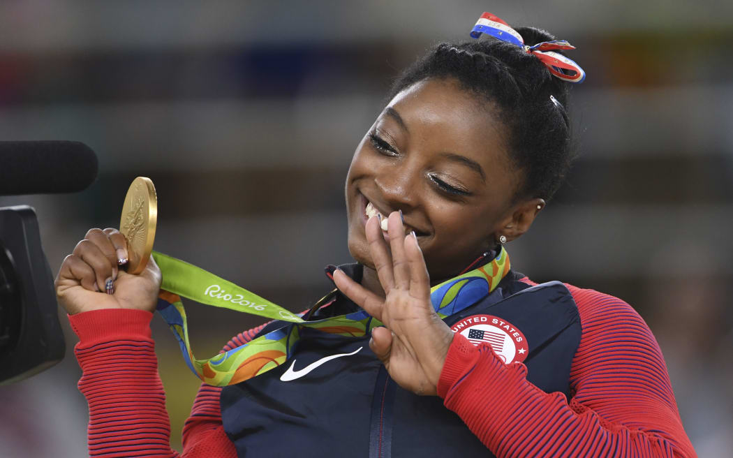 US gymnast Simone Biles celebrates on the podium of the women's floor event final of the Artistic Gymnastics at the Olympic Arena during the Rio 2016 Olympic Games in Rio de Janeiro on August 16, 2016.