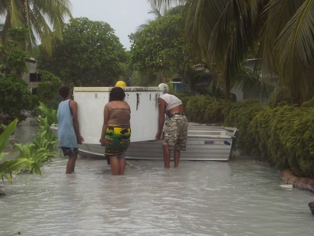 Tuvalu - locals moving a fridge following flooding