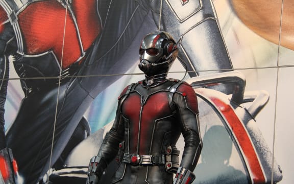 Antman suit in front of movie poster