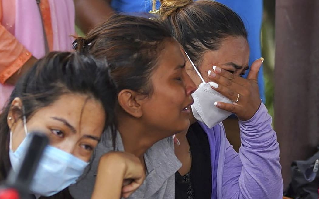 Family members and relatives of passengers on board the Twin Otter aircraft operated by Tara Air, weep outside the airport in Pokhara on May 29, 2022. - A passenger plane with 22 people on board went missing in Nepal on May 29, the operating airline and officials said, as poor weather hampered a search operation. (Photo by Yunish Gurung / AFP)
