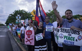 Members of community groups calling for the "de-colonization and de-militarization of Guam" attend a rally for peace in Guam.