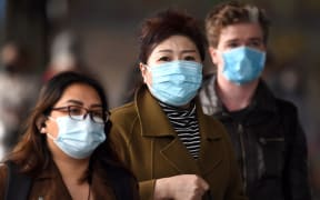 Commuters walk outside Melbourne's Flinders Street Station on July 23, 2020 on the first day of the mandatory wearing of face masks in public areas as the city experiences an outbreak of the COVID-19 coronavirus.