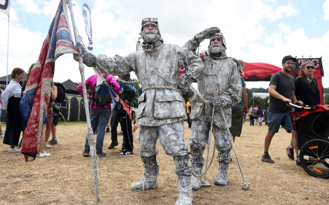 Performers appear as frozen arctic explorers at the Glastonbury festival near the village of Pilton in Somerset, south-west England, on June 25, 2022. - More than 200,000 music fans descend on the English countryside this week as Glastonbury Festival returns after a three-year hiatus. The coronavirus pandemic forced organisers to cancel the last two years' events, and those going this year face an arduous journey battling three days of major rail strikes across the country. (Photo by ANDY BUCHANAN / AFP)