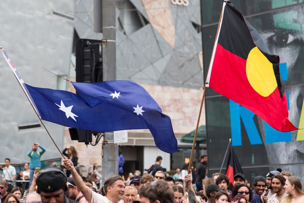 Protestors wave the Australian Flag with the Union Jack cut out and an Aboriginal Flag, during a protest, organized by Aboriginal rights activists on Australia Day in Melbourne,