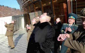 North Korean TV shows Kim Jong-Un, centre, watching the rocket launch.