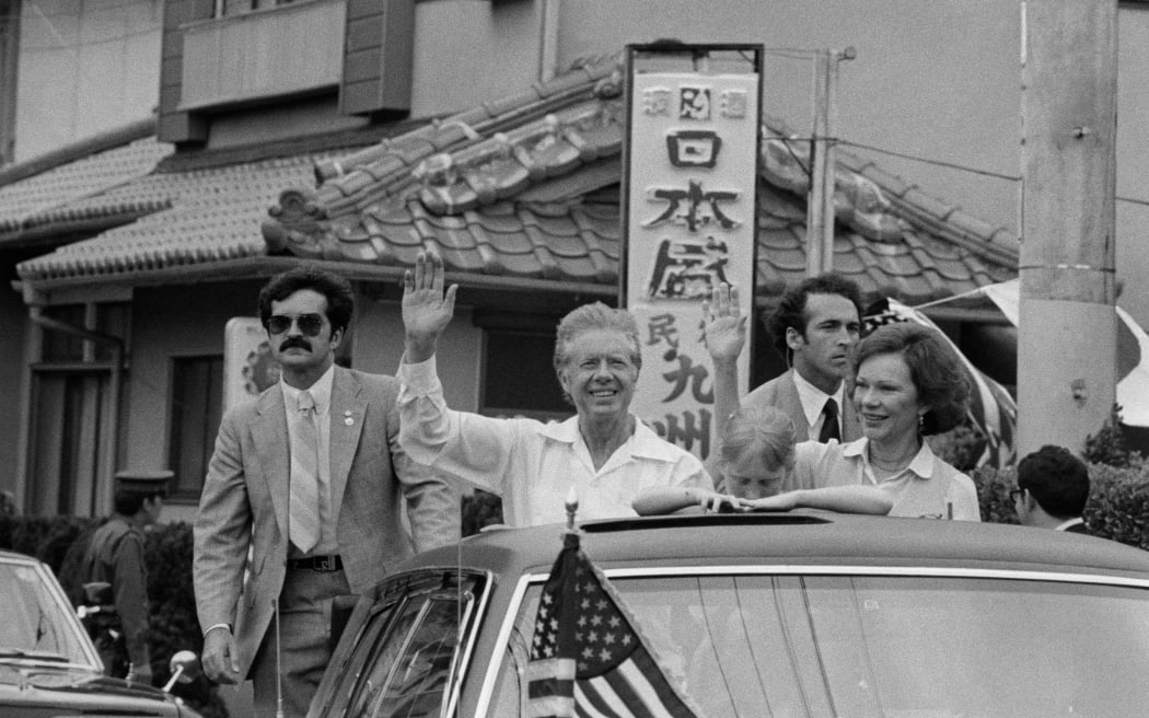 US President Jimmy Carter, accompanied by his wife Rosalynn and their daughter Amy, waves as they visit the city of Shimoda, Japan, on the fringe of the G7 summit on 28 June, 1979.
