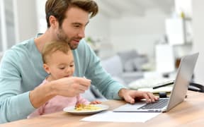 Man working from home and taking care of baby