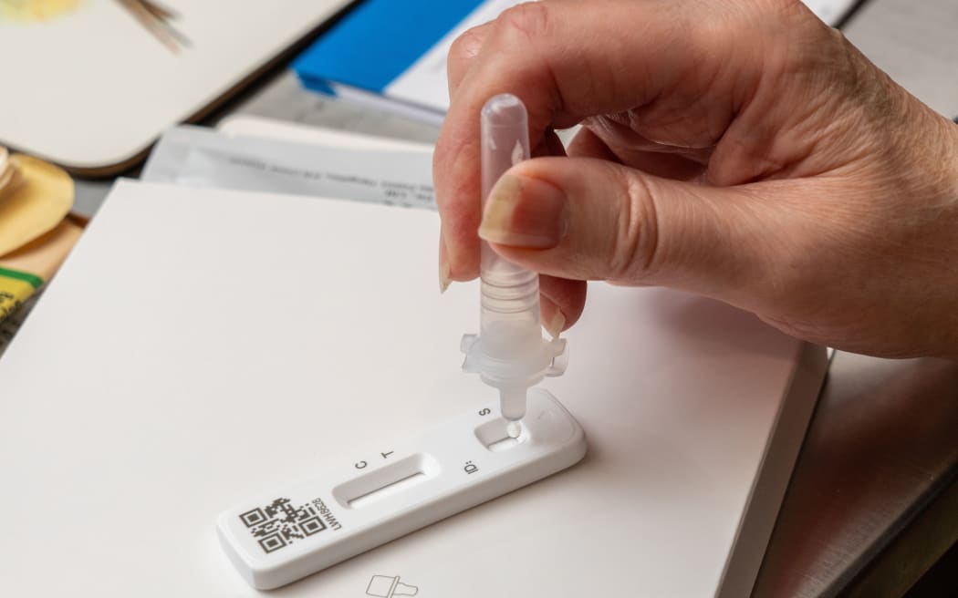 Pruebas de antígeno Covid-19 en curso con la solución tampón goteando en el área de prueba de la tira de resultados