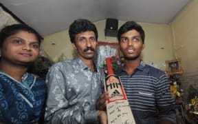 Pranav Dhanawade with his parents and the bat Sachin Tendulkar sent him.