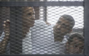 Al-Jazeera news channel's Australian journalist Peter Greste, left, and his colleagues, Egyptian-Canadian Mohamed Fadel Fahmy, centre, and Egyptian Baher Mohamed listen to the original verdict in June.