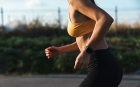 Cropped image closeup of slim woman in sportswear running while doing workout outdoors