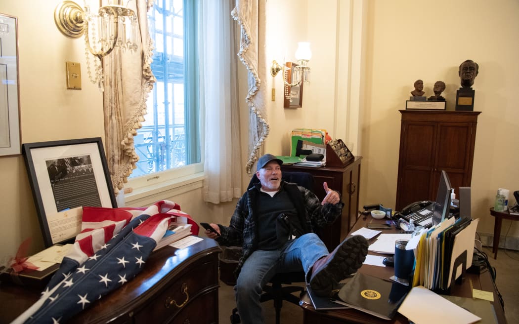 Richard Barnett, a supporter of US President Donald Trump sits inside the office of US Speaker of the House Nancy Pelosi as he protest inside the US Capitol in Washington, DC, January 6, 2021.