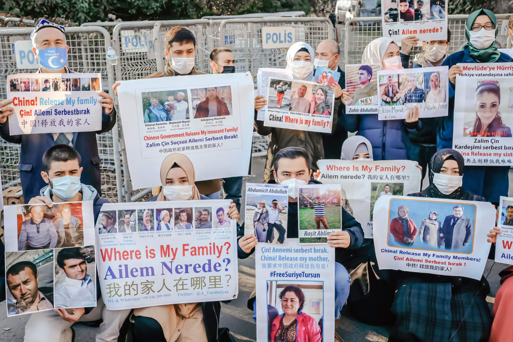Members of the Muslim Uighur minority hold placards as they demonstrate in front of the Chinese consulate on 30 December 2020, in Istanbul, to ask for news of their relatives and to express their concern after China announced the ratification of an extradition treaty with Turkey.