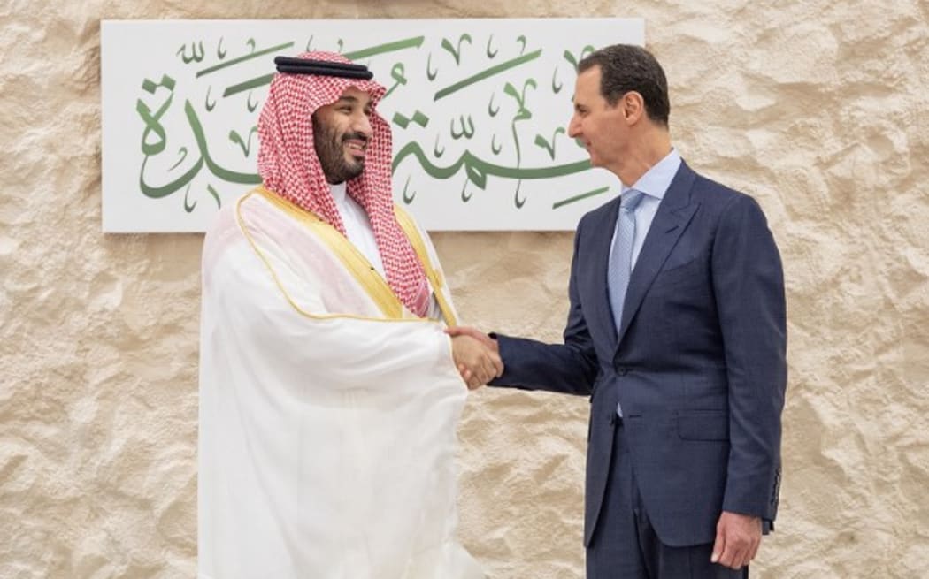Saudi Crown Prince Mohammed bin Salman (L) shakes hands with Syria's President Bashar al-Assad on the sidelines of the Arab Summit meeting in Jeddah.