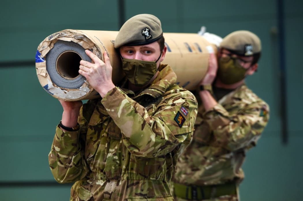 Members of the Royal Scots Dragoon Guards, all wearing face coverings, work to convert a sports hall into a Covid 19 vaccination centre at the Donald Dewar Centre in Glasgow, on January 20, 2021.