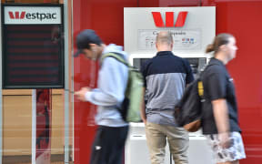 A man uses an ATM machine outside a branch of the Westpac bank in Sydney. Generic.