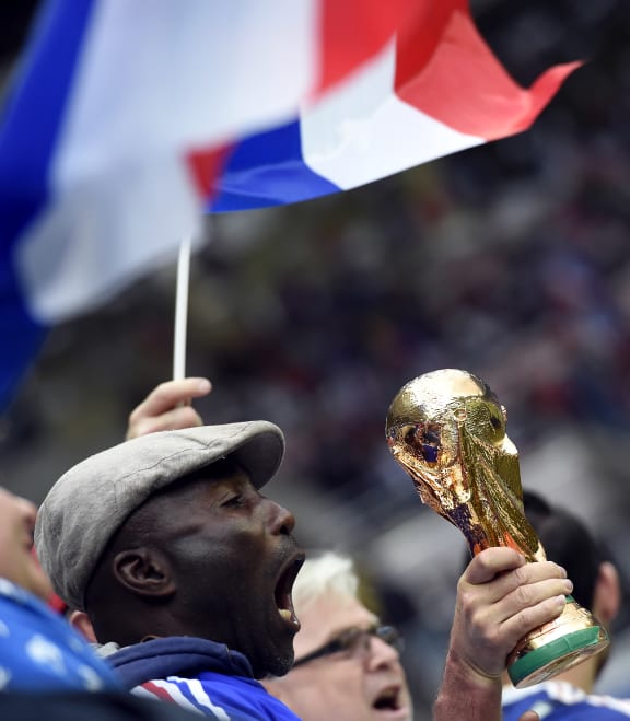 A supporter holds a fake trophy at a France/Paraguay friendly match ahead of the World Cup.