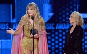 Taylor Swift accepts the Artist of the Decade award from Carole King onstage during the 2019 American Music Awards at Microsoft Theater on November 24, 2019 in Los Angeles, California.