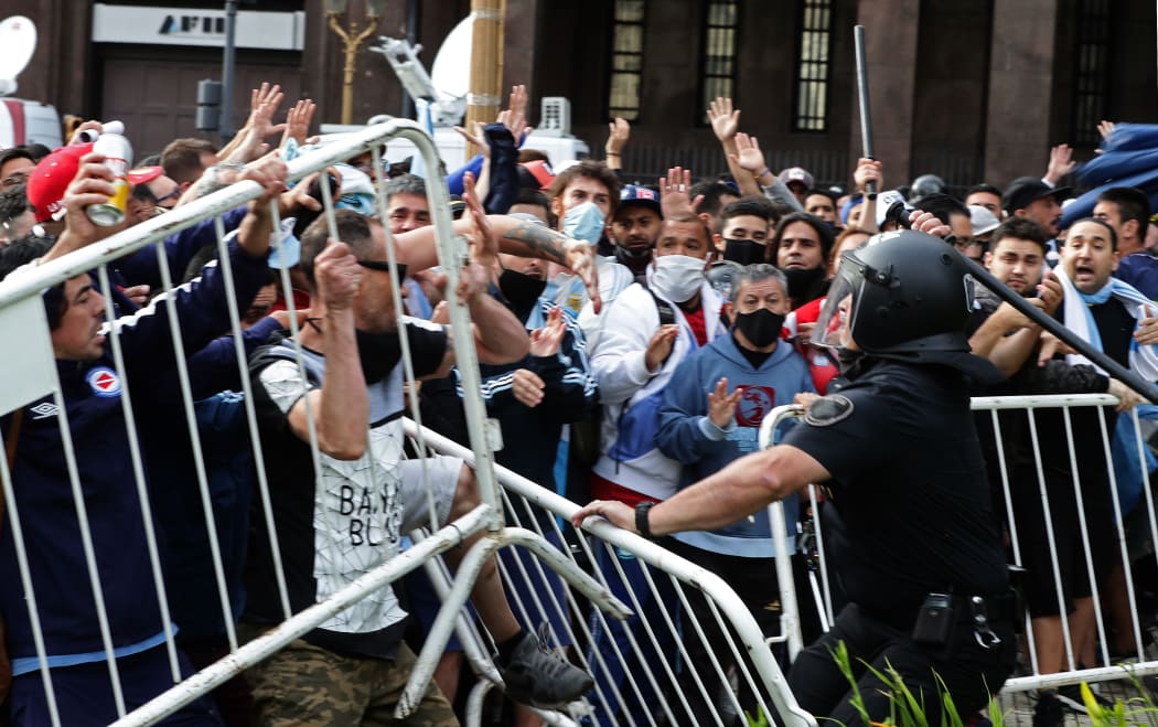 Diego Maradona's fans clash with police as they try to get in to Government House to pay tribute to late football legend Diego Maradona, in Buenos Aires, 26 November.