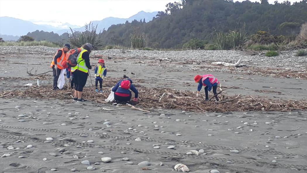 South Westland Coastal Cleanup volunteers helping clear litter and detritus swept into rivers and beaches from a disused landfill after the storm.