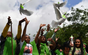 People release doves outside St Helen's church as part of commemorations on the anniversary of the Grenfell fire in West London.
