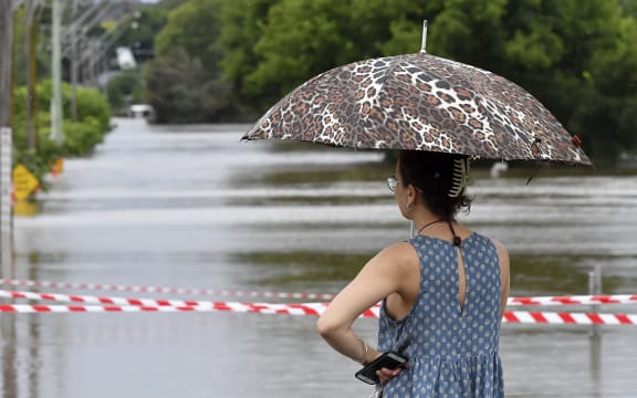A resident watches the rising floodwaters due to the heavy rain in residential area of southwestern Camden suburb of Sydney on March 8, 2022.