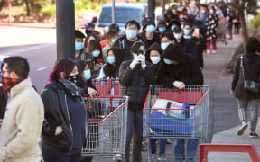 Shoppers wait in a long queue outside a Costco outlet in Melbourne on August 2, 2020 as people queue for provision with the Victorian state government expected to annouce harsh new restrictions due to the city battling fresh outbreaks of the COVID-19 coronavirus.