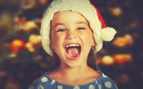 happy child girl in a Christmas hat waiting for a miracle