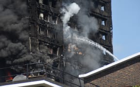 Smoke and flames billows from Grenfell Tower as firefighters attempt to control a blaze at a residential block of flats at Ladbroke Grove, London on 14 June, 2017.