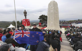 A New Zealand flag being held at a memorial service in April 2015 in front of Ataturk Memorial on Chunuk Bair near Anzac Cove in Gallipoli.