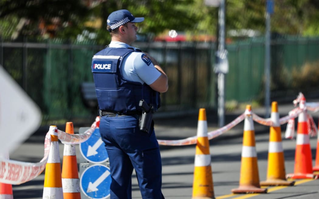 A police officer stands at a cordon in Riccarton, Christchurch, as officers investigate an unexplained death on Matipo Street.
