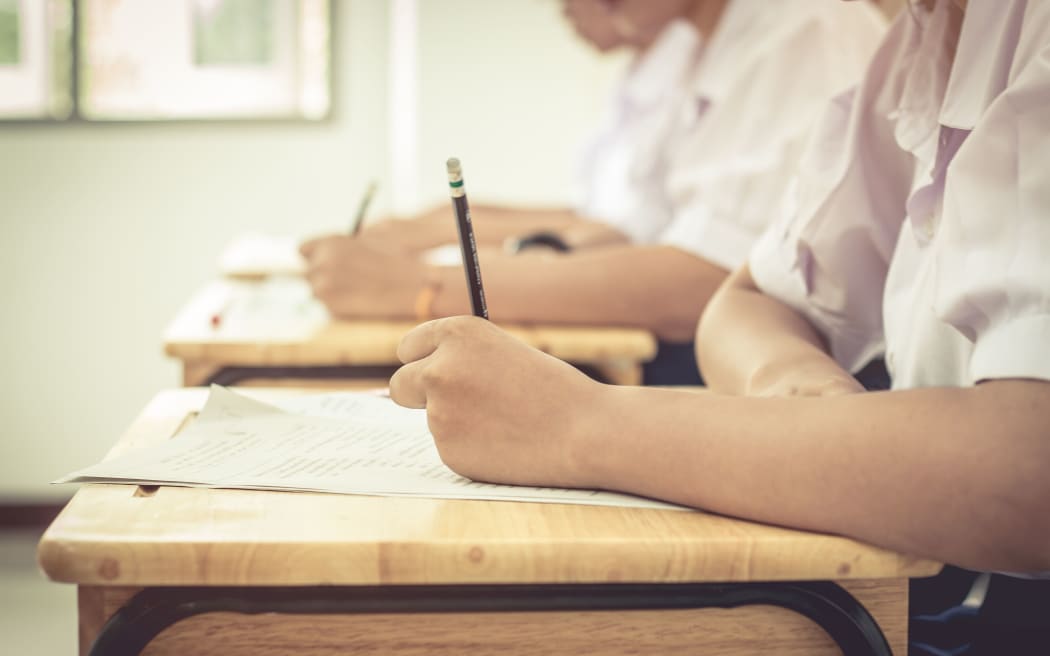 亚洲女学生在泰国的排座学校教室里为高中入学考试写试卷，