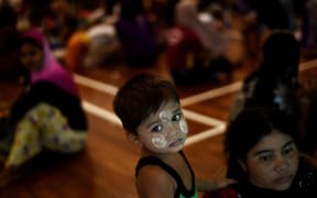 A Rohingya boy waits with other illegal migrants at a temporary detention center in Langkawi, Malaysia.