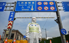 A transit officer, wearing a protective gear, controls access to a tunnel in the direction of Pudong district in lockdown as a measure against the Covid-19 coronavirus.