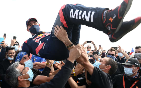 Mini's driver Stephane Peterhansel celebrates with teammates their victory after winning the Dakar Rally 2021, at the end of the last stage between Yanbu and Jeddah, Saudi Arabia, on January 15, 2021. -
