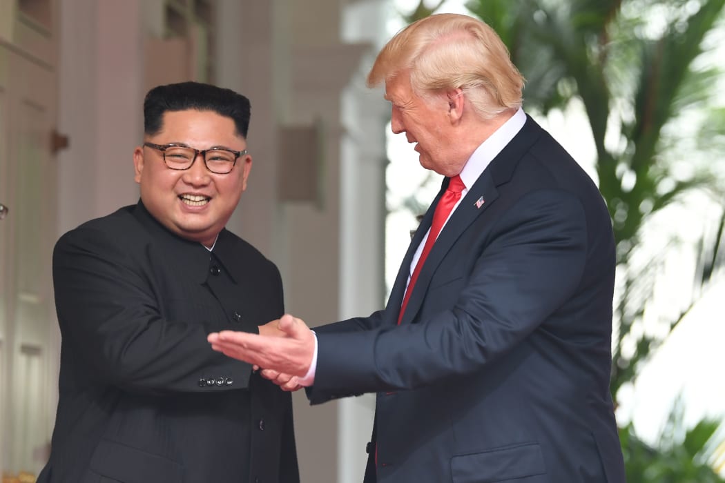 US President Donald Trump (R) gestures as he meets with North Korea's leader Kim Jong Un (L) at the start of their historic US-North Korea summit, at the Capella Hotel on Sentosa island in Singapore on June 12, 2018.